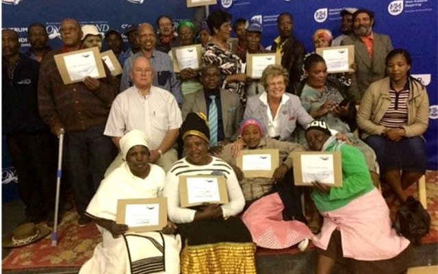 Minister Madikizela and Executive Mayor Nicolette Botha-Guthrie flanked by Councillors, the Deputy Mayor and beneficiaries during the hand-over of 183 title deeds.